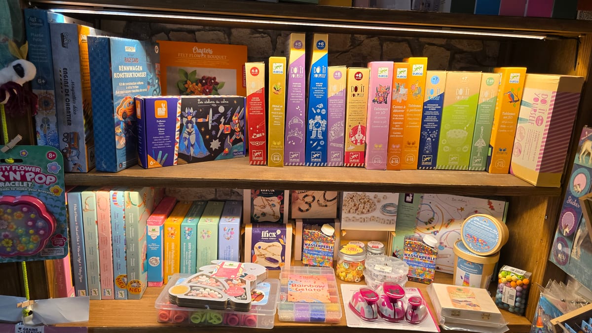 Regal mit Bastelsets von Djeco und anderen Marken bei SPIELschlau in Jena