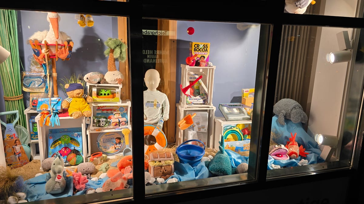 Beleuchtetes Schaufenster von SPIELschlau im Teichgraben in Jena bei Nacht